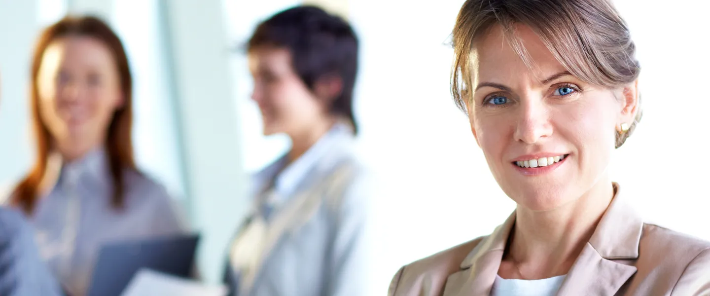 A business woman looks directly at the camera.