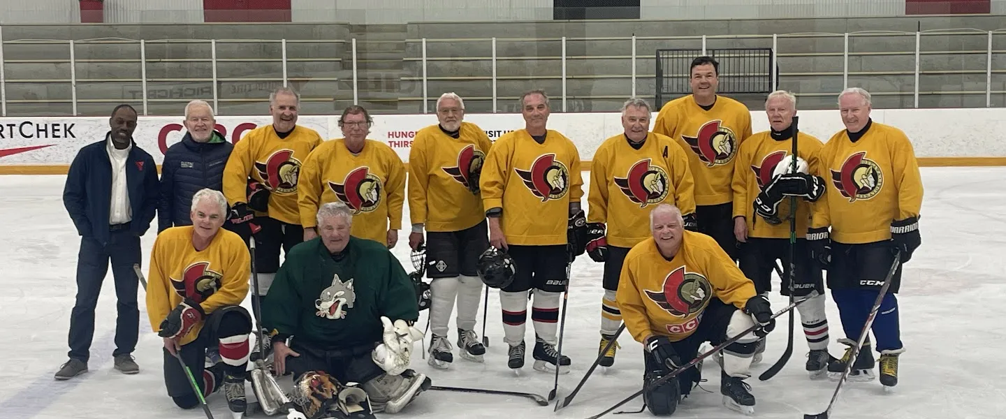 The Ottawa Firebirds team on the ice. They have yellow jerseys with the Ottawa Senators logo.