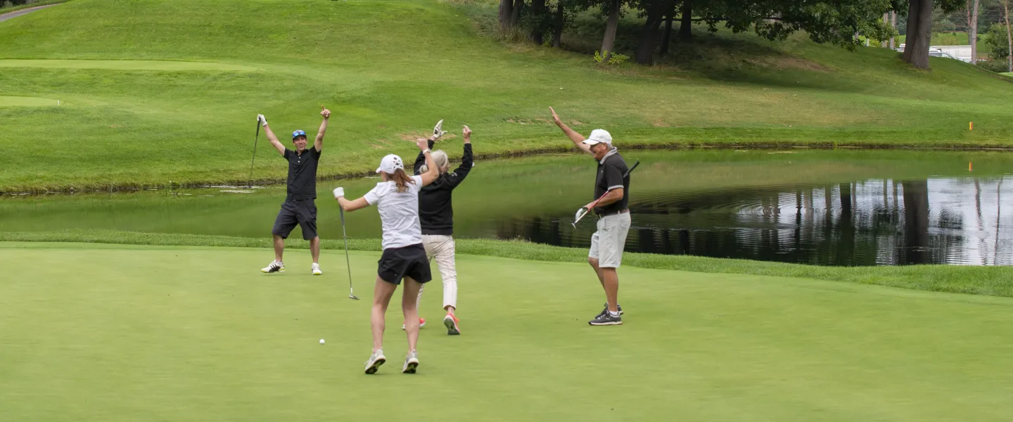 Four golfers celebrating on a golf course