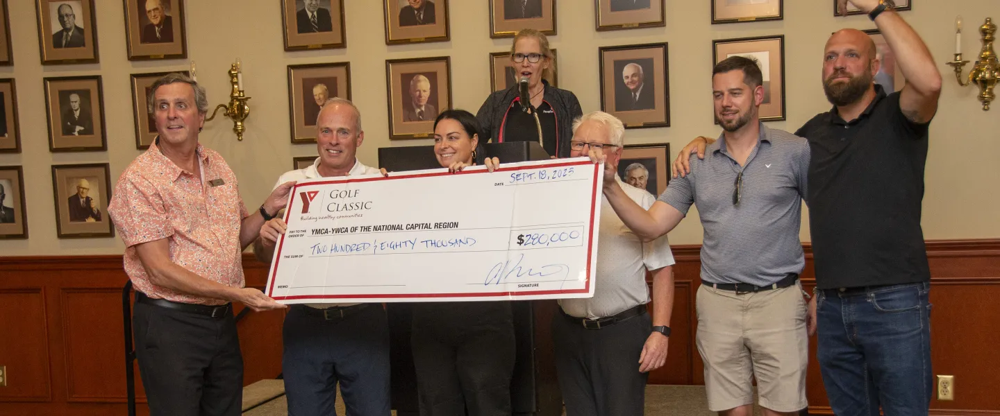 A group of people holding a large cheque for 280,000 dollars