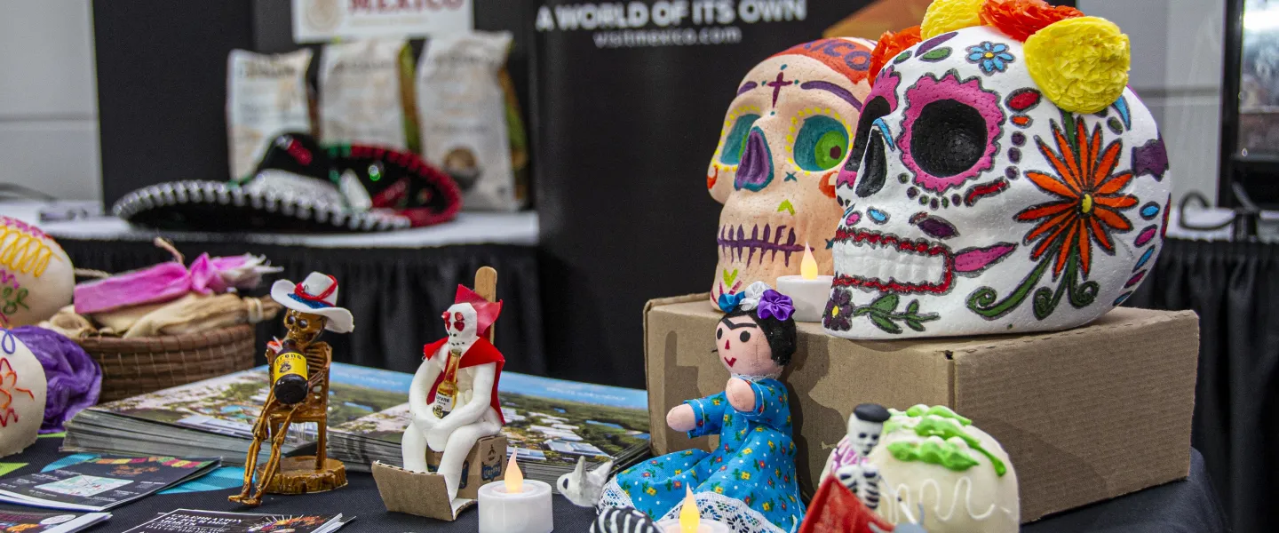 Close up of a table with Mexican crafts and cultural decorations, such as calaveras.