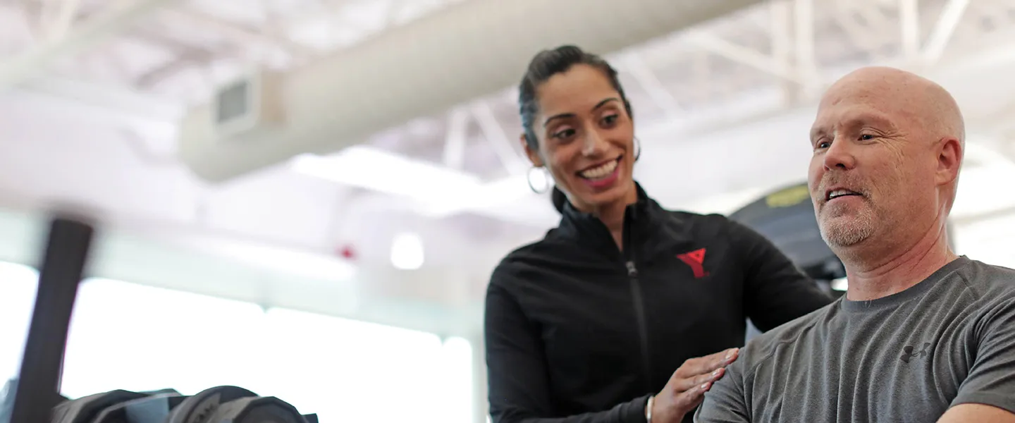 A YMCA personal trainer working with their client.