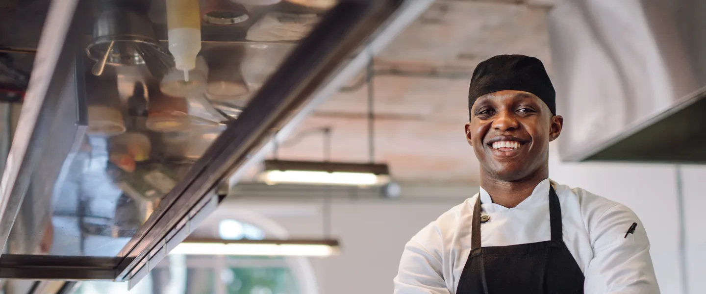 A chef smiling with his arms crossed