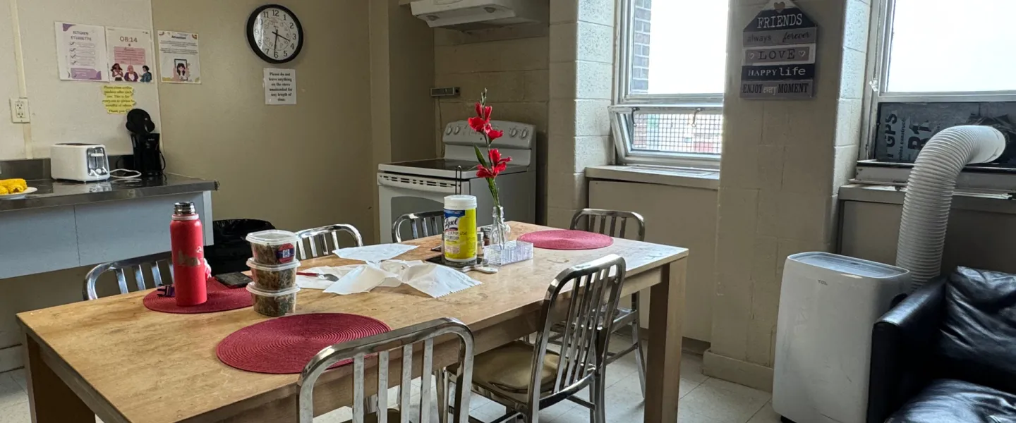 Common space with dining table and kitchen area