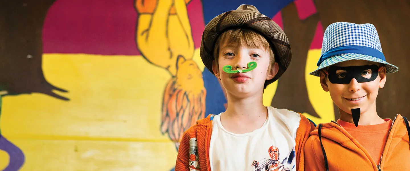 Two boys wearing costumes they made at camp.