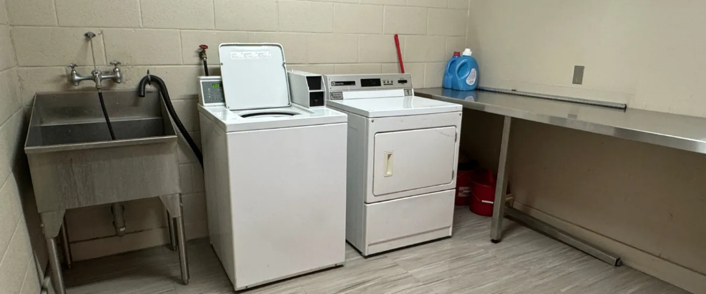 Second Stage Housing laundry room with sink, washer and dryer