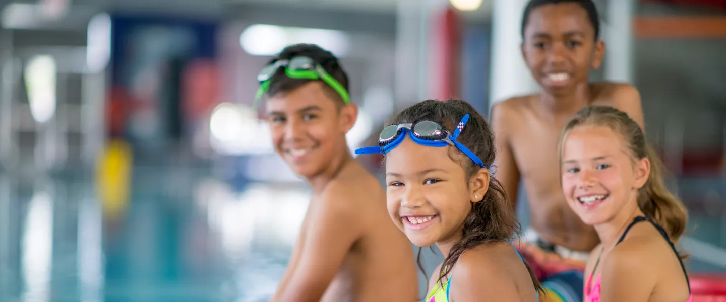 A group of kids playing at a pool