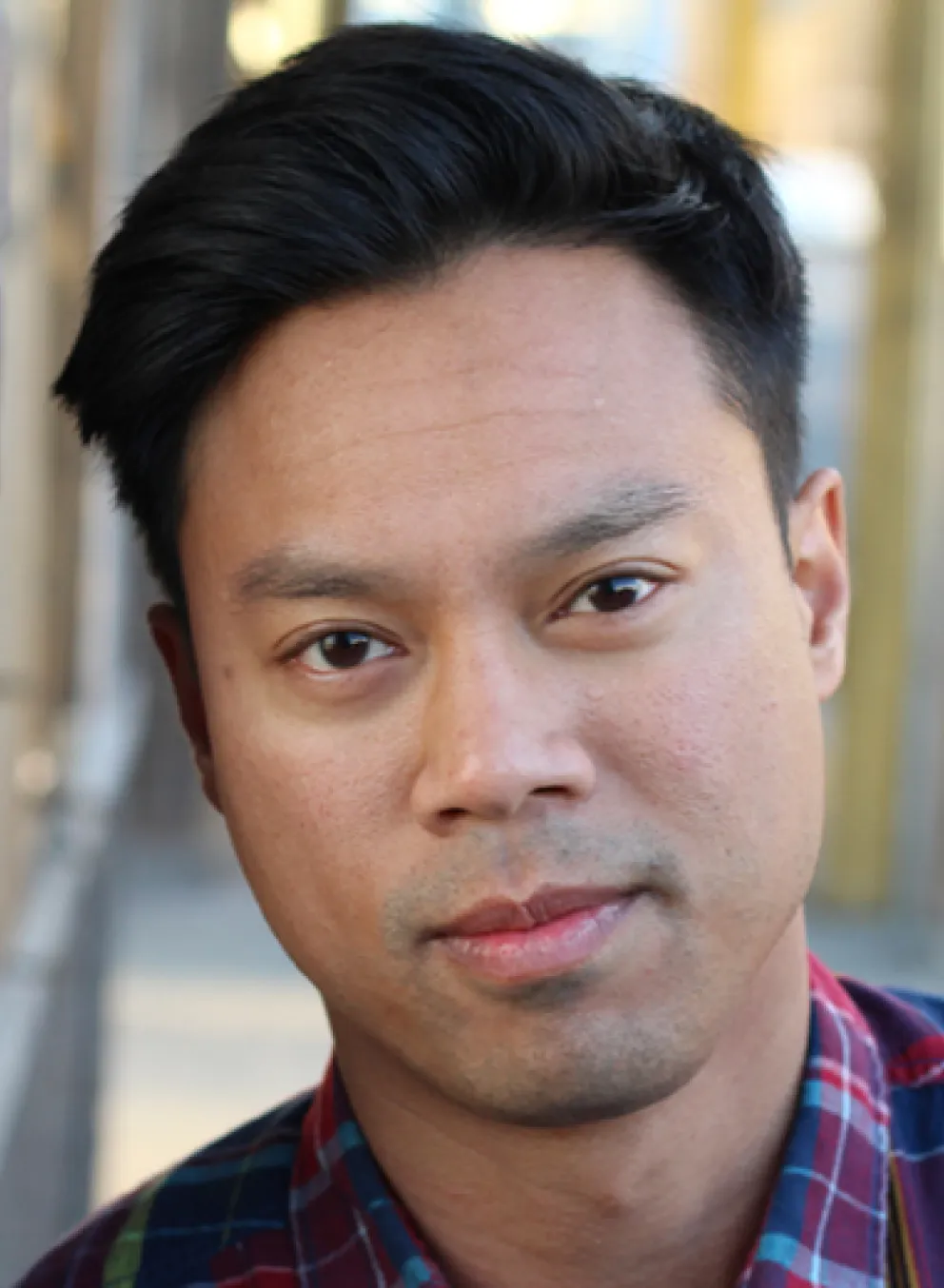 A man leans against a brick wall.