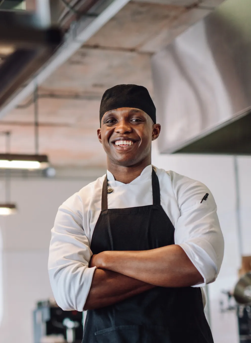 A chef smiling with his arms crossed