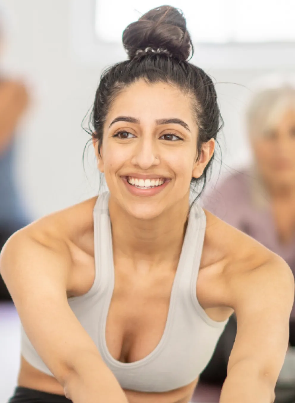 A woman smiles in a group fitness class.