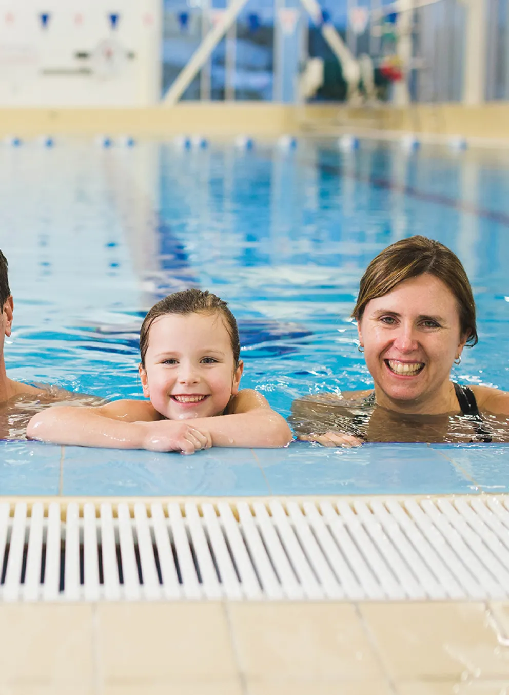 A family of four at the edge of a swimming pool