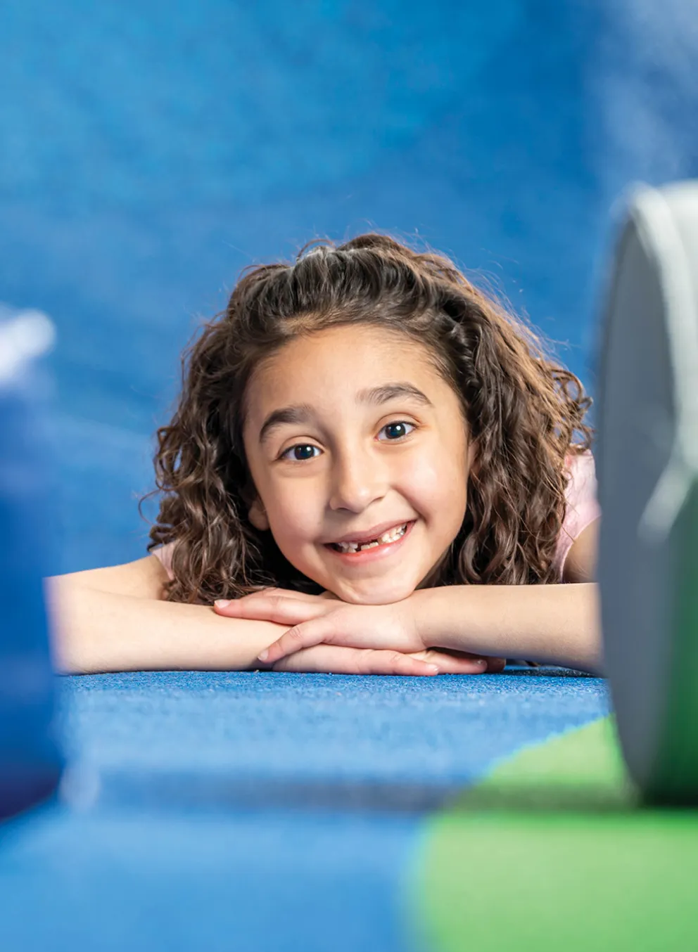 A young girl poses in a soft play area.