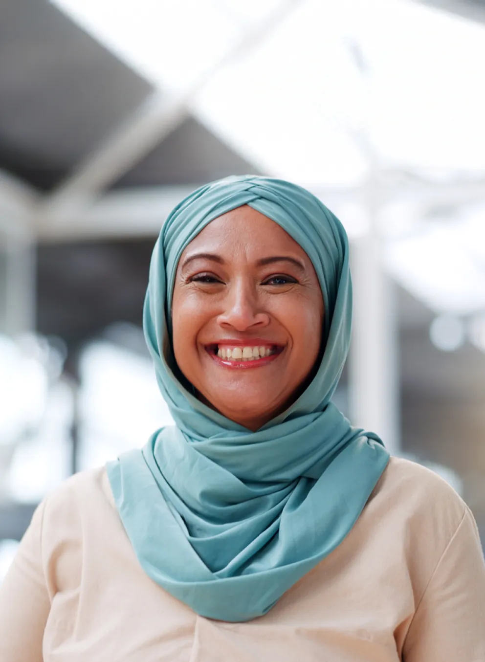 A smiling woman wearing a hijab.