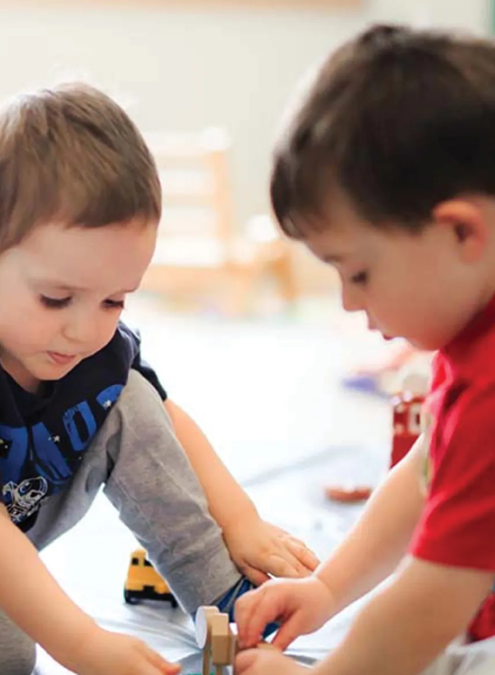 Two children play on the floor.