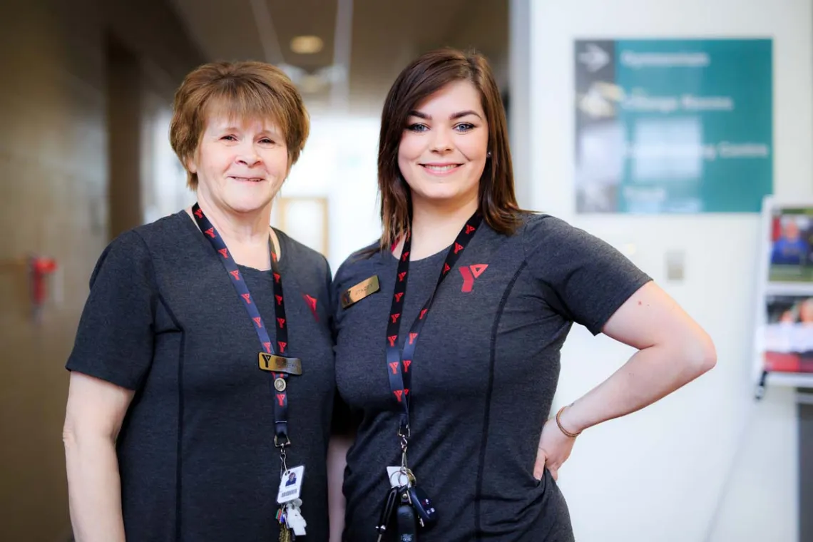 Two Y staff women stand smiling beside each other.