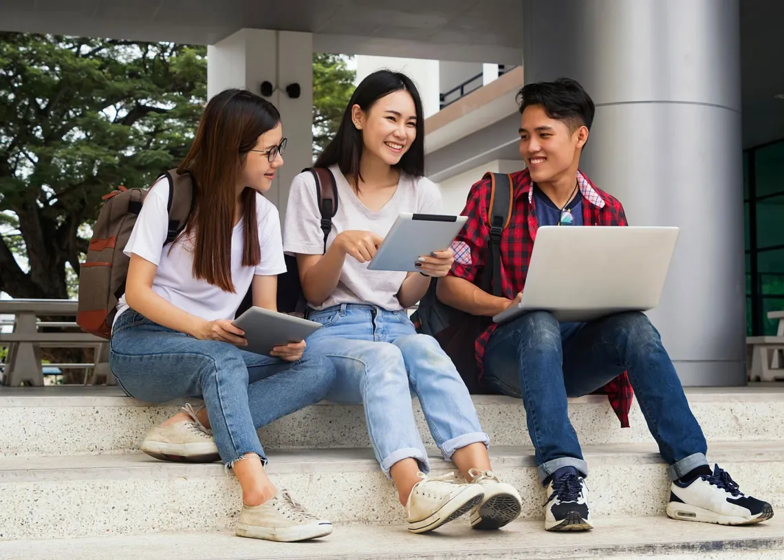 Three smiling youth sitting together. 