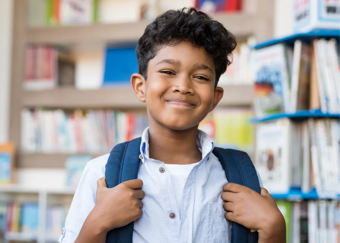 Boy smiles in library.